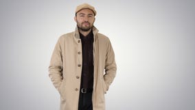 Confident man in trench holding hands in the pockets and walking on gradient background. royalty free stock images Confident man in trench holding hands in the pockets and walking on gradient background. royalty free stock images