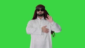 Cool sheikh in sunglasses posing looking to camera on a Green Screen, Chroma Key.