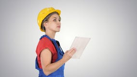 Female construction engineer looking at tablet and checking object on gradient background. stock photo Female construction engineer looking at tablet and checking object on gradient background. stock photo
