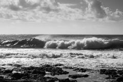 Medium waves crashing on the rocks, grey sky with clouds Stock Photos Medium waves crashing on the rocks, grey sky with clouds Stock Photos