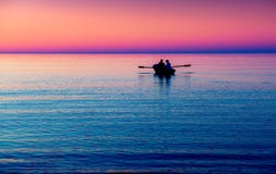 Meerblick mit Boot im Purpur lizenzfreies stockbild Meerblick mit Boot im Purpur lizenzfreies stockbild