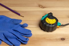 Meetlint, beschermende blauwe handschoenen en een potlood op een stuk van hout royalty-vrije stock foto's Meetlint, beschermende blauwe handschoenen en een potlood op een stuk van hout royalty-vrije stock foto's
