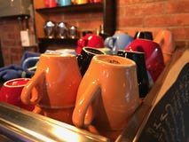 Mehrfarbige Kaffee- und Teeschalen gelegen auf einer Kaffeemaschine gegen eine Backsteinmauer lizenzfreies stockbild Mehrfarbige Kaffee- und Teeschalen gelegen auf einer Kaffeemaschine gegen eine Backsteinmauer lizenzfreies stockbild