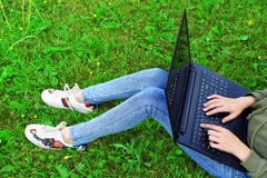 Meisje die laptop buiten op gras met behulp van royalty-vrije stock afbeelding Meisje die laptop buiten op gras met behulp van royalty-vrije stock afbeelding