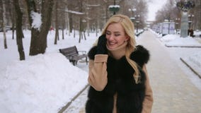 Meisje die op de telefoon in het Park van de de winterstad spreken stock videobeelden Meisje die op de telefoon in het Park van de de winterstad spreken stock videobeelden