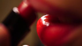 Meisje die rode lippenstift, macrovideo gebruiken stock video Meisje die rode lippenstift, macrovideo gebruiken stock video