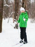 Meisje in een groen jasje die terwijl het ski?en in het de winterbos stellen royalty-vrije stock foto Meisje in een groen jasje die terwijl het ski?en in het de winterbos stellen royalty-vrije stock foto