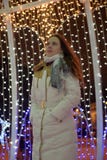Meisje in een witte laag in de winter en gloeiende Kerstmisslinger royalty-vrije stock afbeeldingen Meisje in een witte laag in de winter en gloeiende Kerstmisslinger royalty-vrije stock afbeeldingen