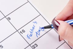 Meisjeshanden met de blauw gevoelde pen het schrijven Dag van woordenvaders in kalender royalty-vrije stock afbeelding Meisjeshanden met de blauw gevoelde pen het schrijven Dag van woordenvaders in kalender royalty-vrije stock afbeelding
