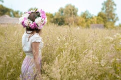 Meisjestribunes op het tot bloei komende gebied van de de lenteavond in een bloemkroon royalty-vrije stock afbeeldingen Meisjestribunes op het tot bloei komende gebied van de de lenteavond in een bloemkroon royalty-vrije stock afbeeldingen