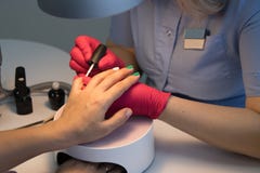 Meister im Schönheitssalon, der einen Farbüberzieher-Manikürekunden erhält lizenzfreie stockfotos Meister im Schönheitssalon, der einen Farbüberzieher-Manikürekunden erhält lizenzfreie stockfotos