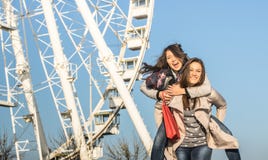 Mejores amigos de las mujeres jovenes que disfrutan de tiempo así como transporte por ferrocarril en la noria de Luna Park foto de archivo Mejores amigos de las mujeres jovenes que disfrutan de tiempo así como transporte por ferrocarril en la noria de Luna Park foto de archivo
