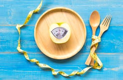 Mela verde con la bilancia e nastro di misurazione per il dimagramento di dieta sana fotografia stock Mela verde con la bilancia e nastro di misurazione per il dimagramento di dieta sana fotografia stock