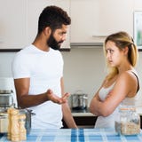 Mellan skilda raser familjpar med allvarliga framsidor som grälar i kitc arkivfoto Mellan skilda raser familjpar med allvarliga framsidor som grälar i kitc arkivfoto