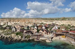 Mellieha, Malta 30 de dezembro de 2018 - casas coloridas de madeira na opinião do plateau de filmagem da vila de Popeye da baía d imagens de stock royalty free Mellieha, Malta 30 de dezembro de 2018 - casas coloridas de madeira na opinião do plateau de filmagem da vila de Popeye da baía d imagens de stock royalty free