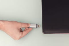 Memória Flash do metal de USB disponível com o laptop conectado Fotografia de Stock Memória Flash do metal de USB disponível com o laptop conectado Fotografia de Stock