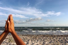 Men hands in praying sign on sand beach by the sea against blue sky with clouds. Stock Photo Men hands in praying sign on sand beach by the sea against blue sky with clouds. Stock Photo