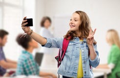 Menina adolescente do estudante que toma o selfie pelo smartphone foto de stock royalty free Menina adolescente do estudante que toma o selfie pelo smartphone foto de stock royalty free