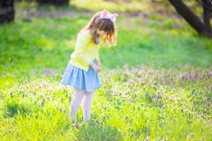 Menina ador?vel que senta-se na grama verde que joga no jardim na ca?a do ovo da p?scoa fotos de stock Menina ador?vel que senta-se na grama verde que joga no jardim na ca?a do ovo da p?scoa fotos de stock