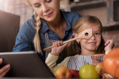 Menina alegre que tem o divertimento com sua mãe na cozinha fotografia de stock royalty free Menina alegre que tem o divertimento com sua mãe na cozinha fotografia de stock royalty free