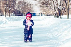 A menina anda no inverno em uma aleia nevado imagens de stock royalty free A menina anda no inverno em uma aleia nevado imagens de stock royalty free