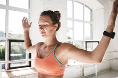 A menina apta de Taned que descansa entre o exercício aproxima o gym ensolarado interno imagens de stock A menina apta de Taned que descansa entre o exercício aproxima o gym ensolarado interno imagens de stock