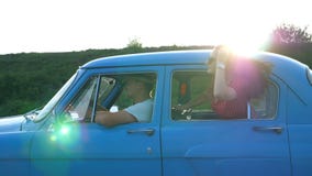 Menina atrativa nos óculos de sol que inclinam-se fora da janela de carro do vintage e que apreciam a viagem Curso novo dos pares vídeos de arquivo Menina atrativa nos óculos de sol que inclinam-se fora da janela de carro do vintage e que apreciam a viagem Curso novo dos pares vídeos de arquivo