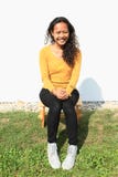 Menina bonita de sorriso que senta-se no moedor de madeira Fotografia de Stock Royalty Free Menina bonita de sorriso que senta-se no moedor de madeira Fotografia de Stock Royalty Free