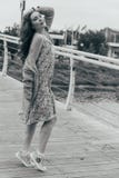A menina bonita está na ponte, o vento funde em sua cara, desenvolvendo seu cabelo Sorrisos da menina foto preto e branco de danç fotografia de stock A menina bonita está na ponte, o vento funde em sua cara, desenvolvendo seu cabelo Sorrisos da menina foto preto e branco de danç fotografia de stock