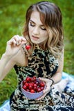Menina bonita que guarda uma bacia de cerejas Verão quente O conce imagem de stock Menina bonita que guarda uma bacia de cerejas Verão quente O conce imagem de stock