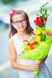 Menina bonita que levanta com um grande ramalhete das flores Menina com cintas e vidros foto de stock royalty free Menina bonita que levanta com um grande ramalhete das flores Menina com cintas e vidros foto de stock royalty free