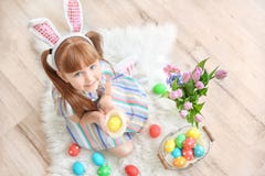 Menina bonito com as orelhas do coelho que guardam o ovo da páscoa brilhante imagens de stock Menina bonito com as orelhas do coelho que guardam o ovo da páscoa brilhante imagens de stock