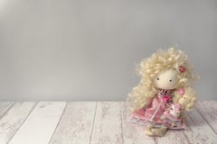 A menina bonito da boneca da tela no vestido cor-de-rosa com coelho branco senta-se em uma tabela de madeira branca com copyspace imagens de stock A menina bonito da boneca da tela no vestido cor-de-rosa com coelho branco senta-se em uma tabela de madeira branca com copyspace imagens de stock