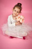 Menina bonito na saia do tule com um ramalhete das flores em um fundo cor-de-rosa fotografia de stock Menina bonito na saia do tule com um ramalhete das flores em um fundo cor-de-rosa fotografia de stock