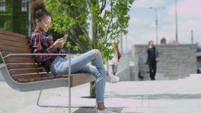 Menina bonito nova que texting em seu telefone em uma cidade filme Menina bonito nova que texting em seu telefone em uma cidade filme