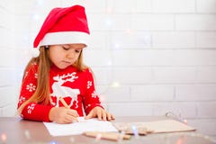 Menina bonito que escreve uma letra a Santa, fundo branco imagem de stock Menina bonito que escreve uma letra a Santa, fundo branco imagem de stock