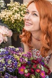 Menina caucasiano do ruivo bonito que cheira flores coloridas no jardim Imagem de Stock Menina caucasiano do ruivo bonito que cheira flores coloridas no jardim Imagem de Stock