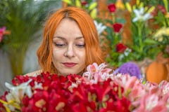 Menina caucasiano do ruivo bonito que cheira flores coloridas no jardim Imagem de Stock Menina caucasiano do ruivo bonito que cheira flores coloridas no jardim Imagem de Stock