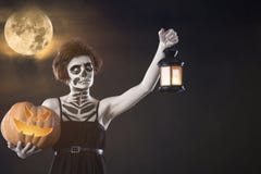 A menina com Dia das Bruxas compõe a abóbora e o castiçal da posse outono imagem de stock A menina com Dia das Bruxas compõe a abóbora e o castiçal da posse outono imagem de stock