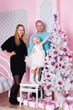 A menina com pais um abeto do White Christmas Foto de Stock A menina com pais um abeto do White Christmas Foto de Stock