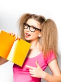 Menina Curly com vidros que aponta no livro aberto imagem de stock Menina Curly com vidros que aponta no livro aberto imagem de stock
