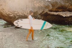 Menina da ressaca com a prancha que vai ao oceano para surfar Menina bonita do surfista fotos de stock royalty free Menina da ressaca com a prancha que vai ao oceano para surfar Menina bonita do surfista fotos de stock royalty free