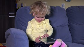 A menina de grito da criança pequena obtém o tablet pc e acalma-se para baixo imediatamente vídeos de arquivo A menina de grito da criança pequena obtém o tablet pc e acalma-se para baixo imediatamente vídeos de arquivo