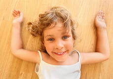A menina de sorriso bonita encontra-se no assoalho imagens de stock A menina de sorriso bonita encontra-se no assoalho imagens de stock
