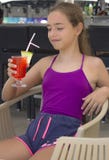 Menina de sorriso feliz com o cocktail vermelho em sua mão fotos de stock Menina de sorriso feliz com o cocktail vermelho em sua mão fotos de stock