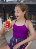 Menina de sorriso feliz com o cocktail vermelho em sua mão fotografia de stock royalty free Menina de sorriso feliz com o cocktail vermelho em sua mão fotografia de stock royalty free