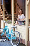 Menina de sorriso no terraço do café do verão com bicicleta retro foto de stock Menina de sorriso no terraço do café do verão com bicicleta retro foto de stock