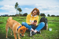 Menina do sorriso do turista na paisagem da natureza do fundo usando o smartphone móvel com amigos cão, terra arrendada da pessoa foto de stock royalty free Menina do sorriso do turista na paisagem da natureza do fundo usando o smartphone móvel com amigos cão, terra arrendada da pessoa foto de stock royalty free