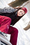A menina doce com snowboard senta-se na neve Fotografia de Stock Royalty Free A menina doce com snowboard senta-se na neve Fotografia de Stock Royalty Free