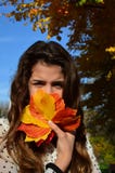 Menina e folhas de outono fotografia de stock royalty free Menina e folhas de outono fotografia de stock royalty free